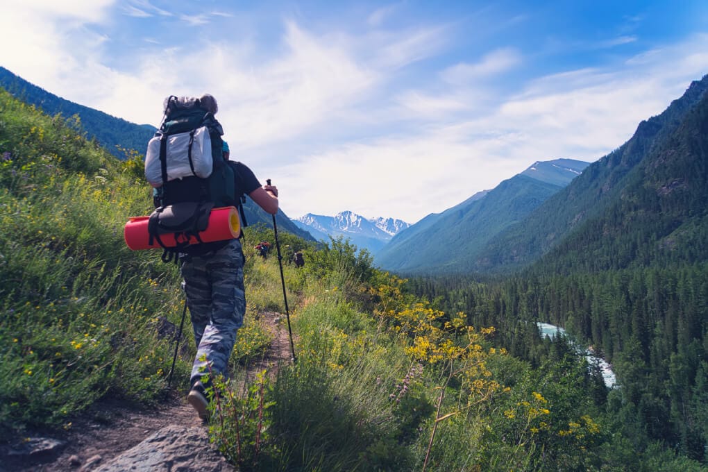 Reisender auf einem Berggipfel mit Rucksack